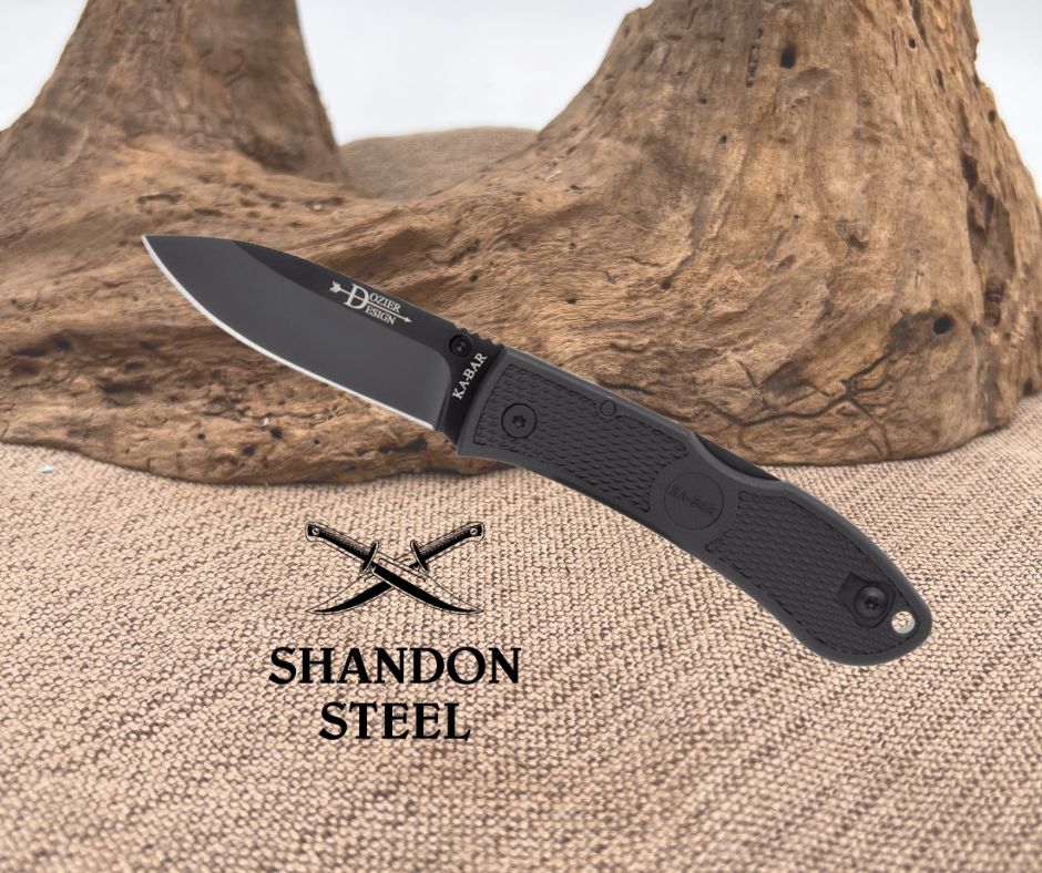 Folding knife with black handle and blade on a wooden surface, featuring Shandon Steel branding.