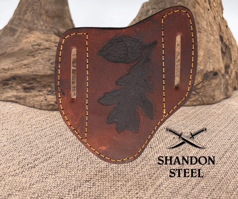 Brown leather sheath with black leaf design on a textured surface, featuring 'Shandon Steel' branding.