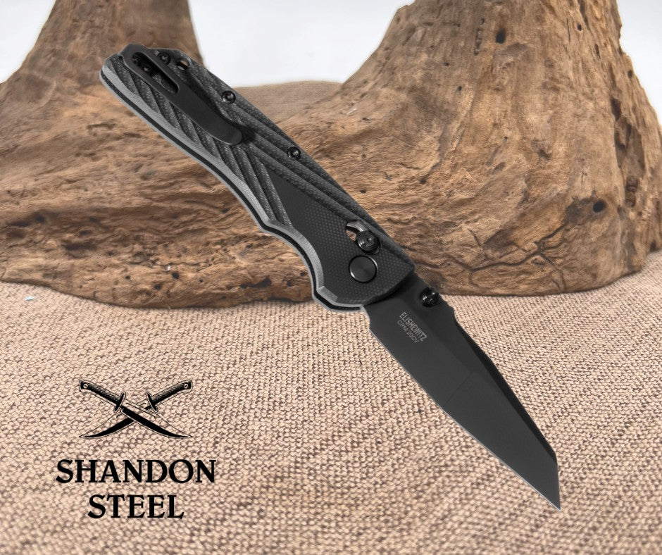Black folding knife on a textured surface with 'Shandon Steel' branding.