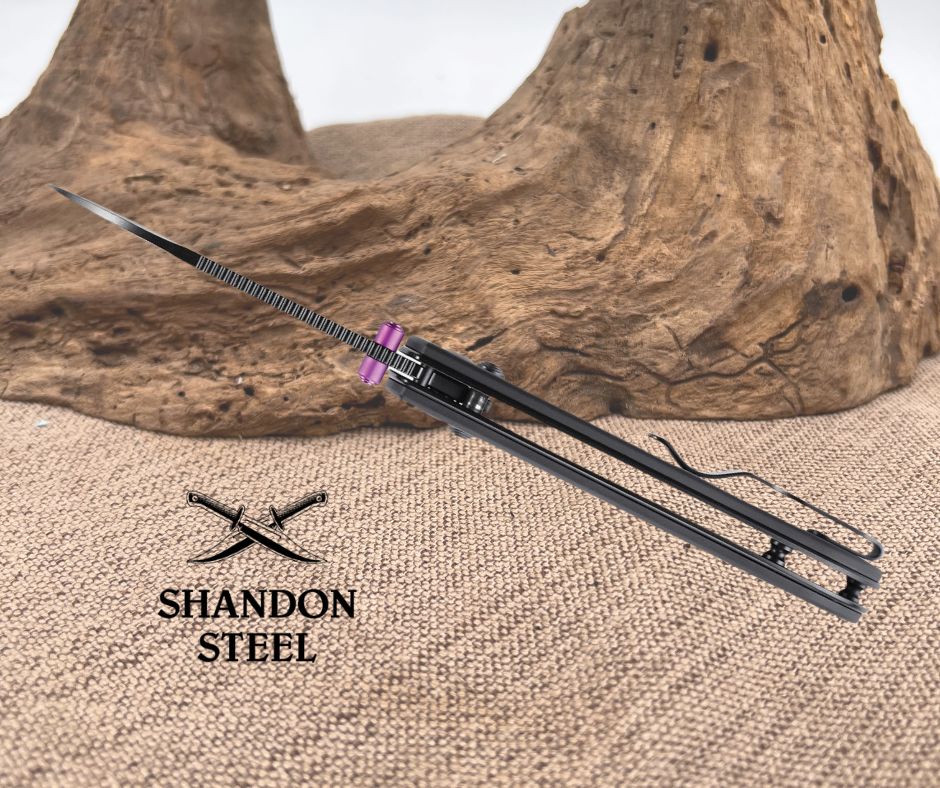 Black sword with pink hilt on a textured surface, Shandon Steel branding visible