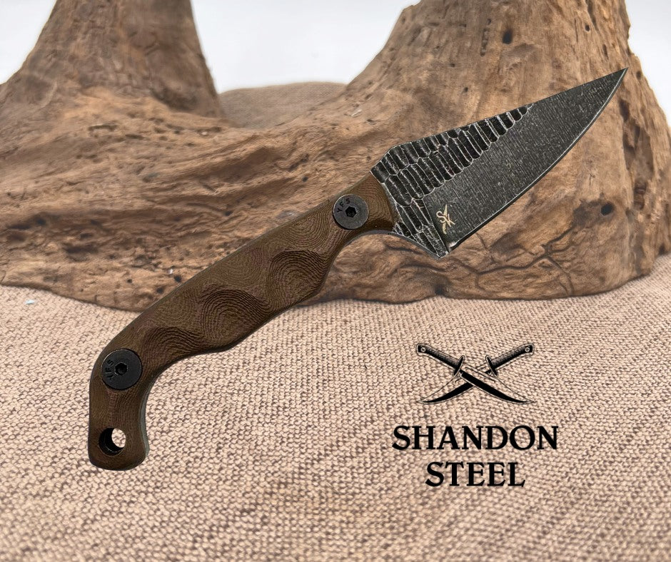 Knife with wooden handle and textured blade on a rustic background, featuring Shandon Steel logo.