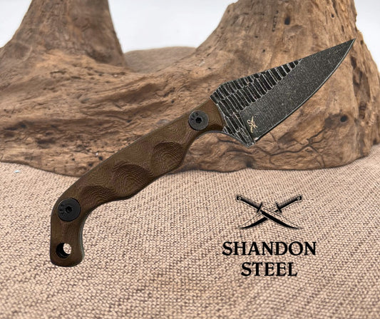 Knife with wooden handle and textured blade on a rustic background, featuring Shandon Steel logo.