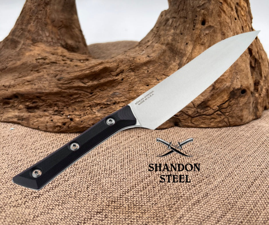 Knife with black handle and silver blade on a textured surface with 'Shandon Steel' branding.