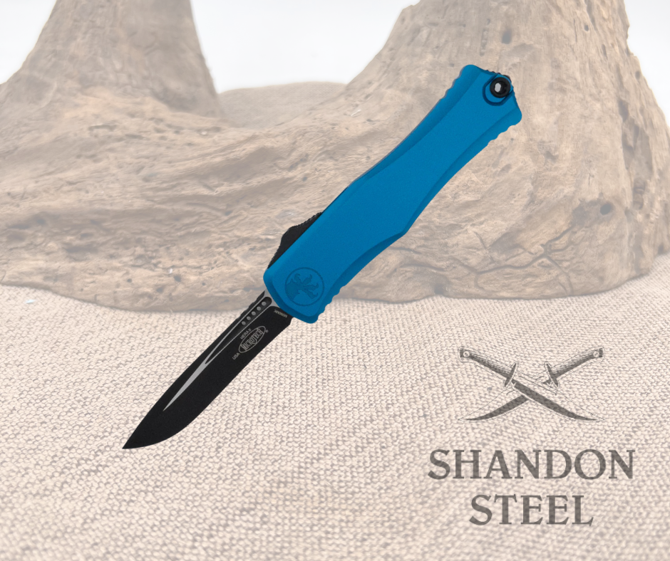 A folding knife with a blue handle and a curved black blade placed on a textured surface with the text 'SHANDON STEEL' visible.