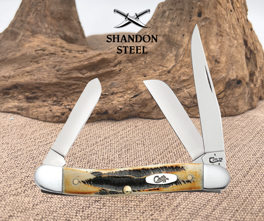 Three-blade pocket knife with wooden handle on a textured surface, branded 'Shandon Steel'.