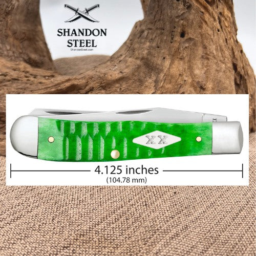 A green and white pocket knife shown on a white measurement card with a line indicating 4.125 inches (104.
