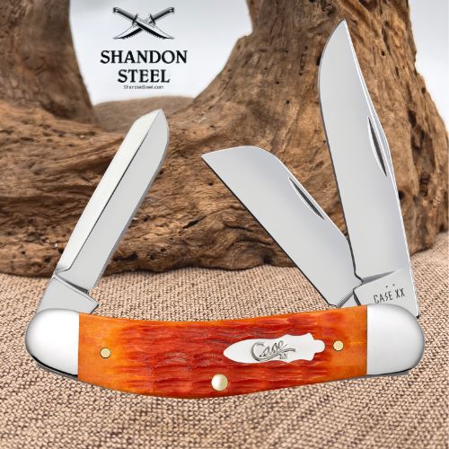 A folding pocket knife with a reddish-orange wood handle and silver steel blades, displayed against a rustic wood log and burlap background. The handle is engraved with 'Case XX' and the top left corner features a 'Shandon Steel' logo overlay.
