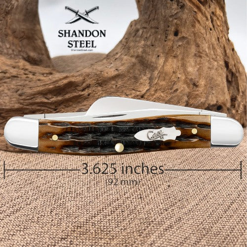 A folding pocket knife with a tortoiseshell handle and silver steel blades, displayed on a burlap surface with a piece of driftwood behind it. A dimension overlay indicates the knife is 3.