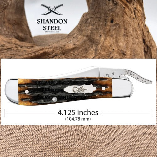 A folding pocket knife with a brown and black textured handle, shown on a white background with a wood texture behind it. The top section shows the Shandon Steel logo over a tree trunk, and the bottom section includes a dimension line indicating the knife is 4.