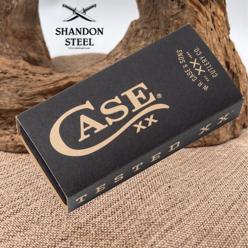 A black box of Case XX cuttlefish oil with leather corda, branded with a large gold 'CASE XX' logo, resting on a burlap surface with a piece of driftwood in the background. The Shandon Steel logo is visible in the top left corner.