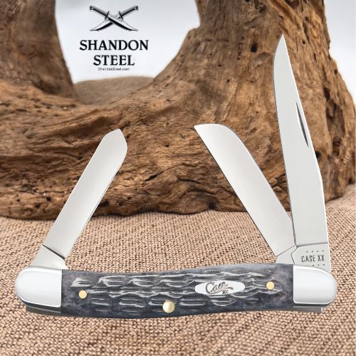 A folding pocket knife with two open blades and a dark patterned handle, displayed in front of a rustic wood prop. The brand logo 'SHANDON STEEL' is visible at the top, and 'CASE XX' is printed on the metal bolster near the right blade base.