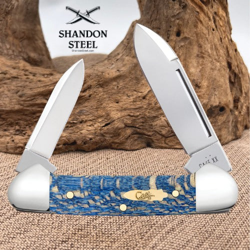A double-blade pocket knife with a blue and beige marbled resin handle, shown open against a rustic wood background. The brand logo 'SHANDON STEEL' is visible in the upper left, and 'Cullinan' is engraved on the handle.