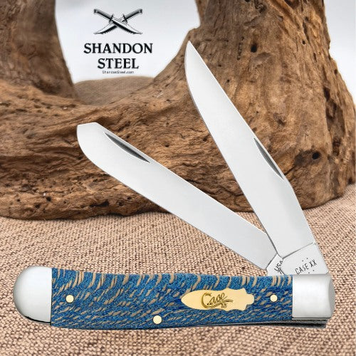 A double-blade pocket knife with a textured blue and gold handle, shown open against a rustic wood background. The brand logo 'Shandon Steel' is visible in the upper left, and the 'Case' logo is engraved on the gold-colored brass accent on the handle.