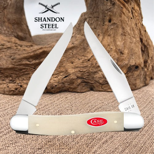 A classic Case XX folding pocket knife with a cream-colored bone handle and stainless steel blades, displayed against a rustic wood and burlap background. The brand logo 'Shandon Steel' is visible in the upper left.