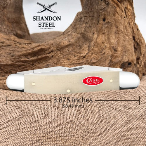 A folding pocket knife shown on a burlap surface with a large piece of driftwood behind it. The image includes a measurement overlay indicating the knife is 3.