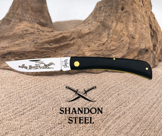 Knife with black handle and visible branding on a textured surface