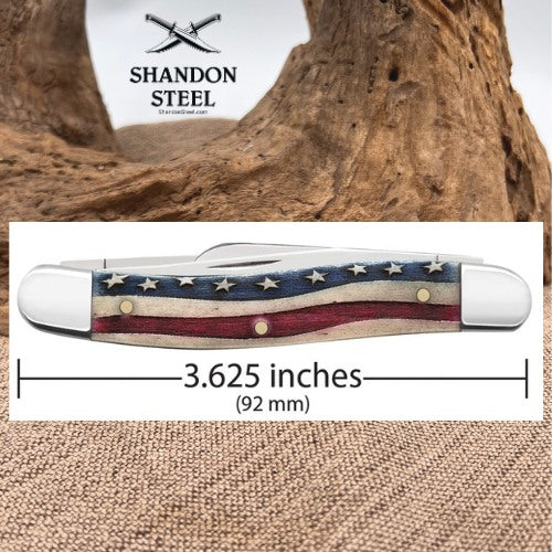 A pocket knife with a distressed American flag handle design, shown with a dimension overlay indicating a 3.625-inch length (92 mm).