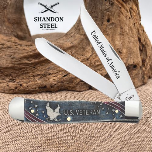 A folding pocket knife with two stainless steel blades, one engraved with 'United States of America,' displayed in front of a rustic wood background. The handle is dark gray with an eagle emblem, the text 'U.