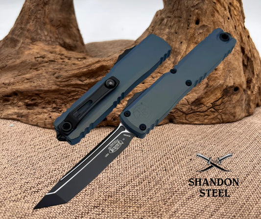 Folding knife with a black blade and handle on a textured surface with 'Shandon Steel' branding.