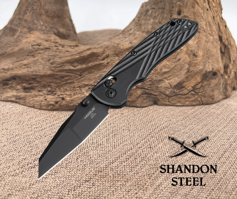 Black folding knife on a textured surface with 'Shandon Steel' branding.