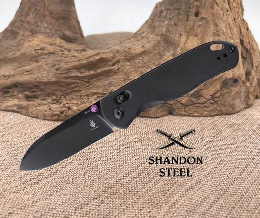 Black folding knife on a textured surface with 'Shandon Steel' branding.