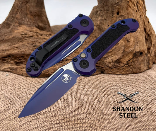 Blue folding knife with black handle on a textured surface, brand 'Shandon Steel' visible