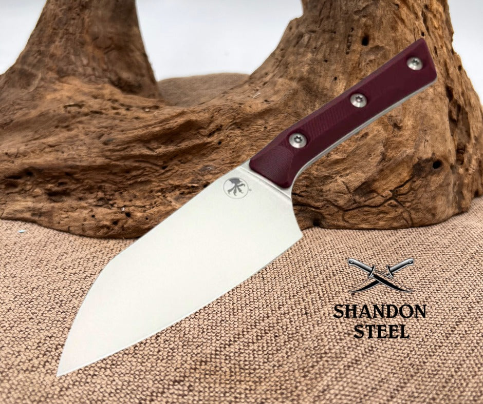 Knife with a maroon handle on a textured surface with 'Shandon Steel' branding.