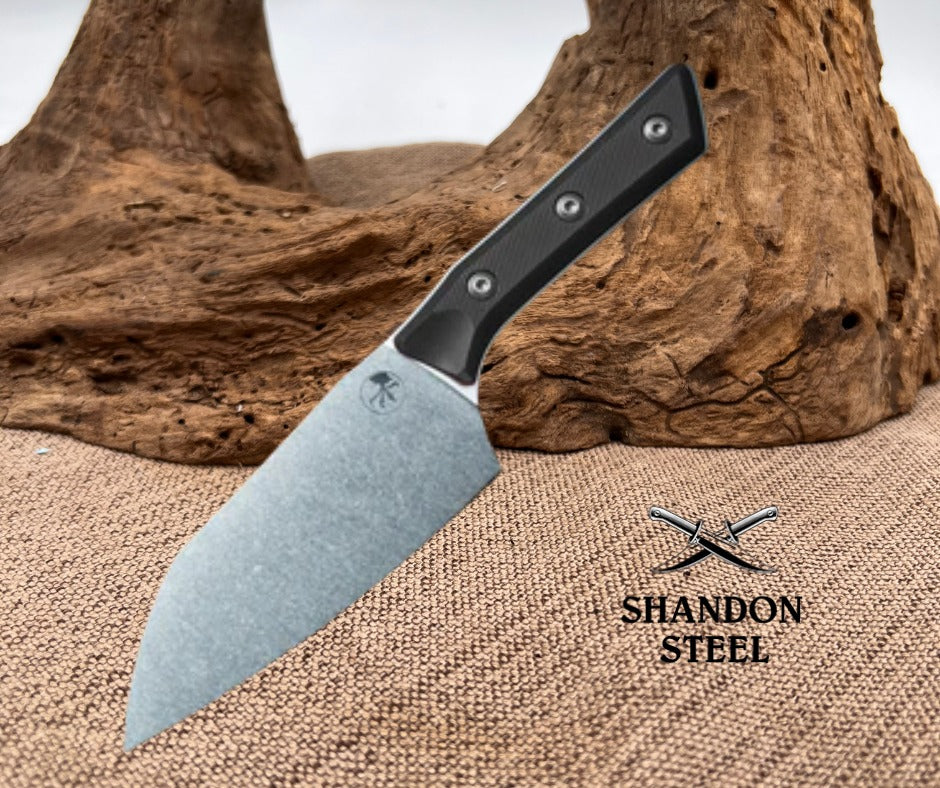 Knife with black handle and silver blade on a textured surface with 'Shandon Steel' branding.