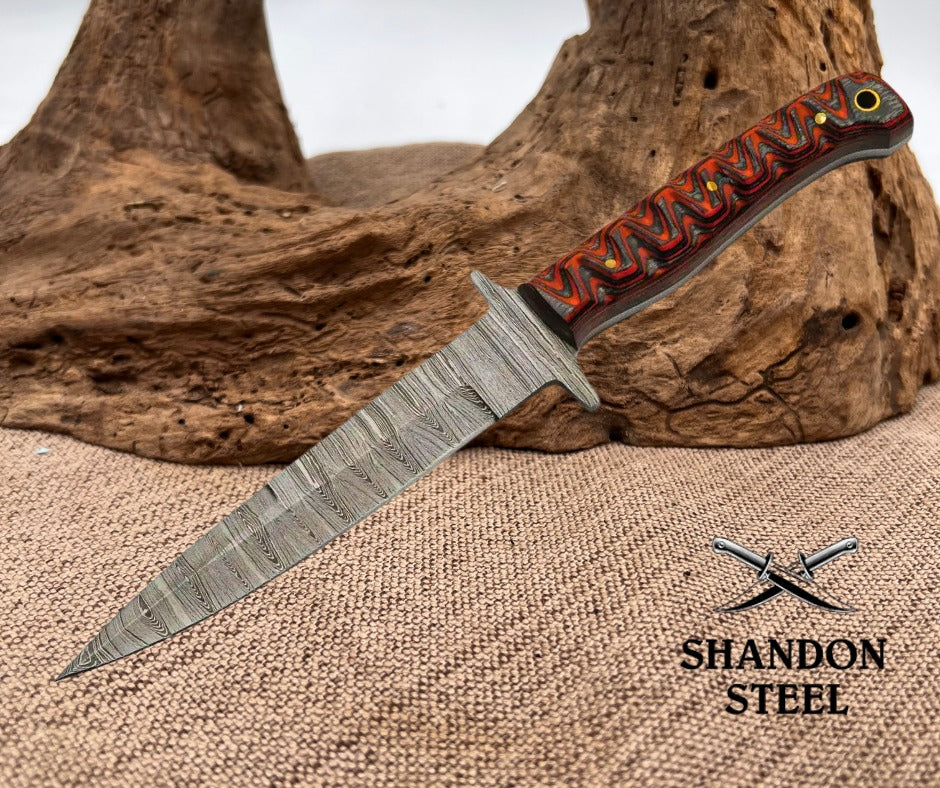 Knife with a decorative handle on a textured surface, featuring the Shandon Steel logo.