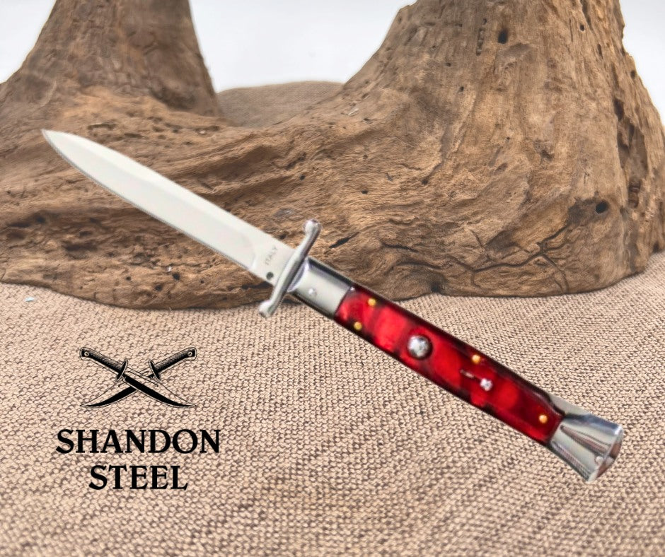  Dagger with red handle on a textured surface, branded 'Shandon Steel'.