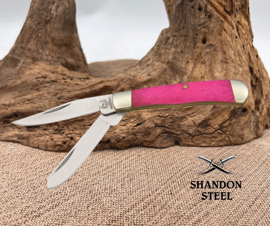 Knife with pink handle on wooden surface, Shandon Steel logo visible